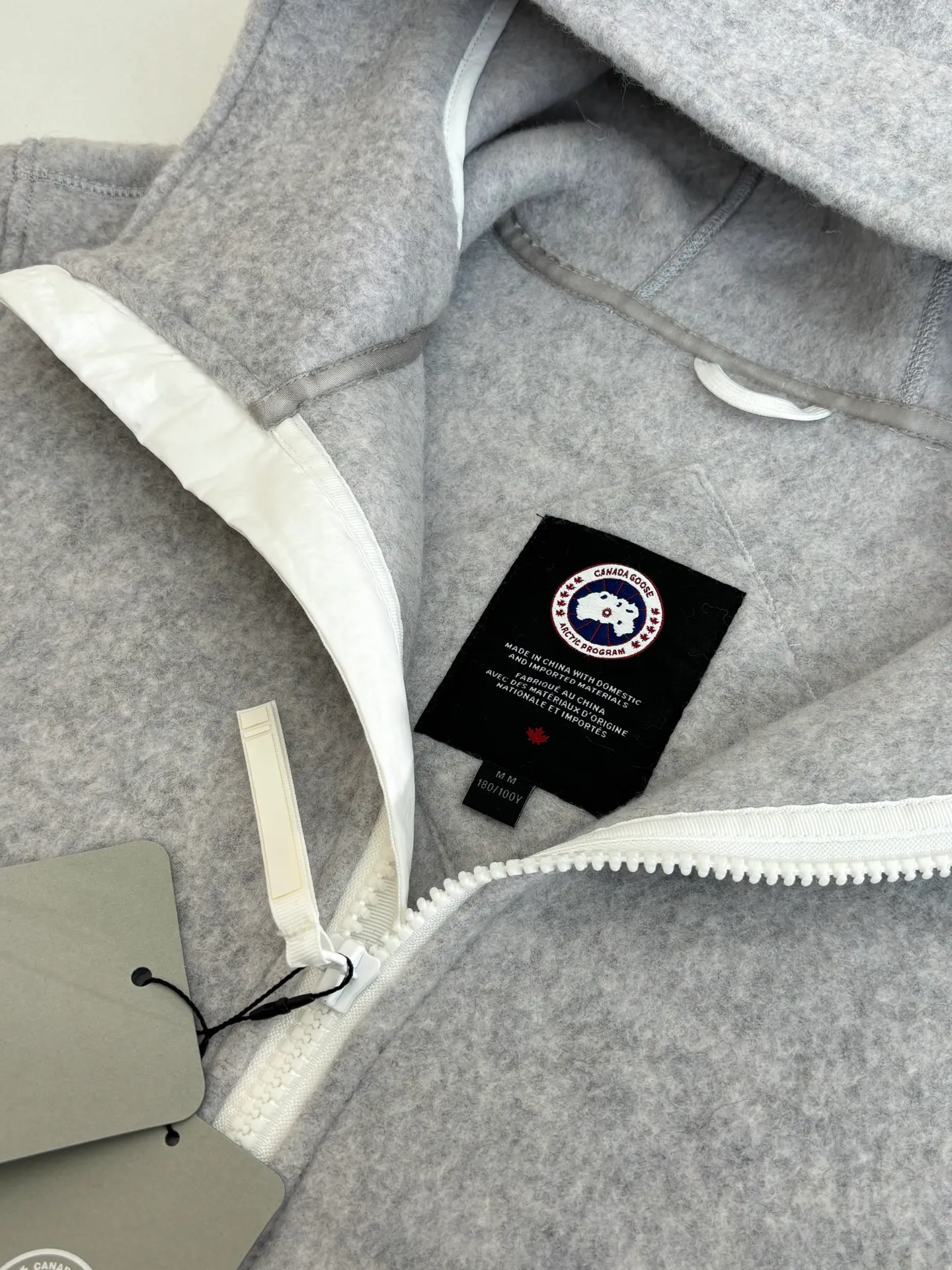 P810 Canada Goos*/Big Goose Fleece Badge Hooded Jacket The fabric is made of wool as the main body, with a very small amount of spandex and polyester fiber blended into the wool fleece fabric. The sleeves and hem are closed with 2×2 ribbing. Its strong elasticity can closely fit wrists and waists of different thicknesses, forming an effective 'seal' to prevent cold wind from blowing back. It can still maintain its original shape after repeated stretching and use, and is not easy to loose and deform. And the ribbed cuffs can convey a sense of design and enhance the visual beauty.  Size：S/M/L/XL